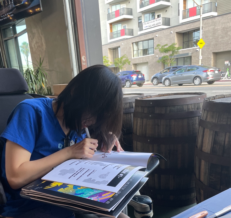 Artist signing a comic at the Trademark Brewery event